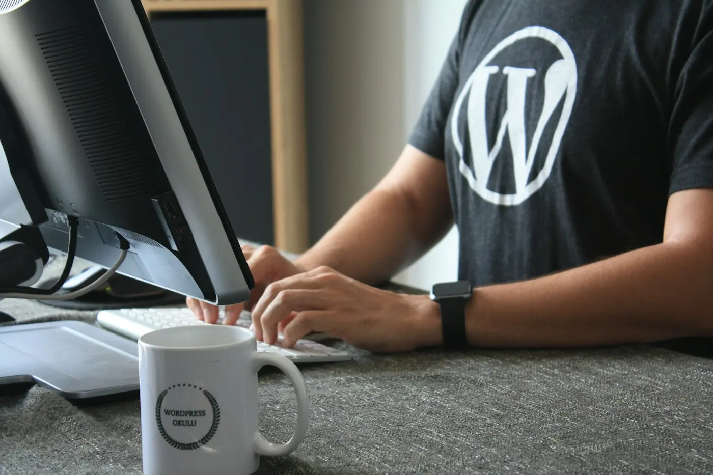Developer in a WordPress t-shirt working at his computer
